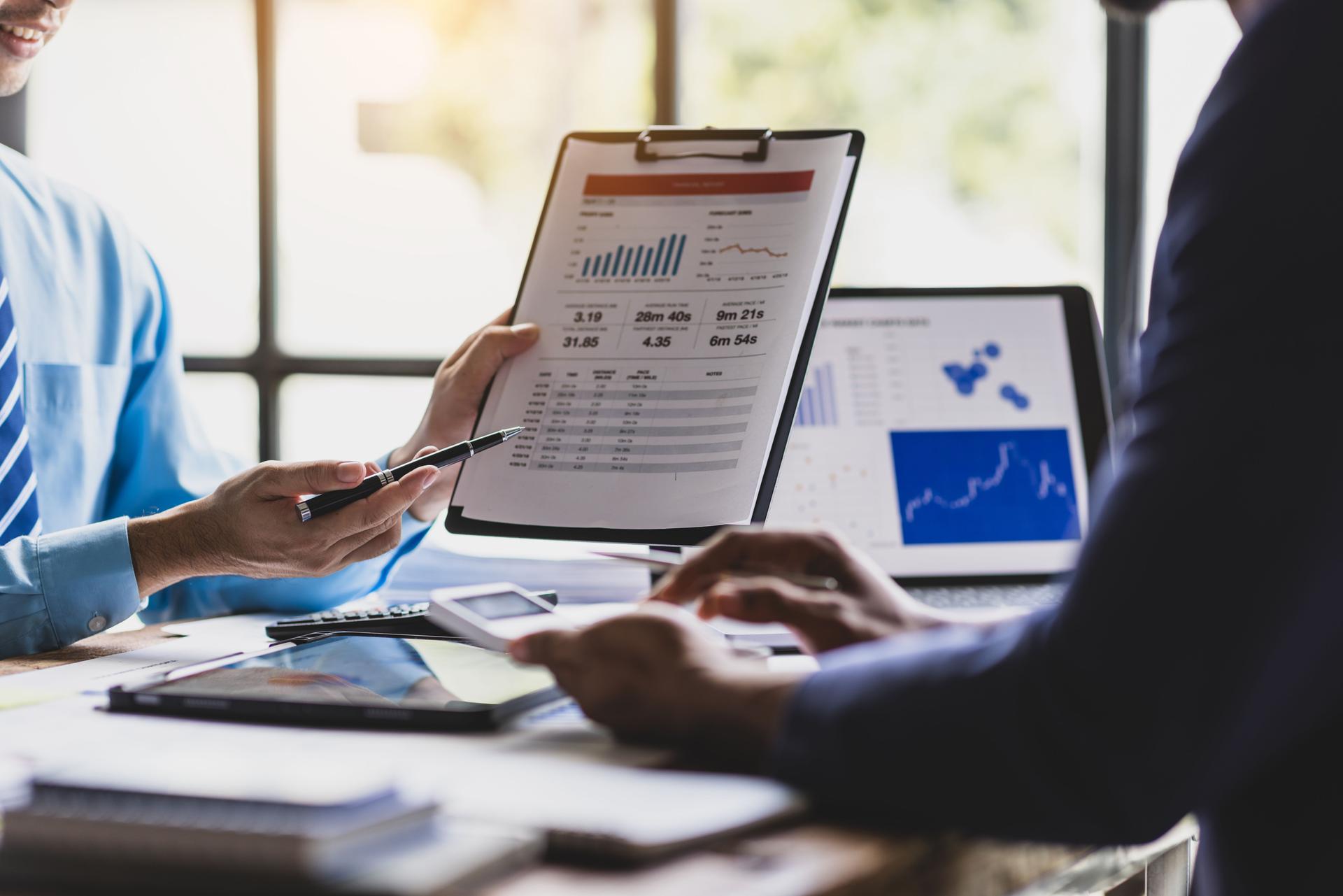 Business consultant analyzing financial charts and planning investment strategy. Business people having a discussion financial investment while analyzing chart.